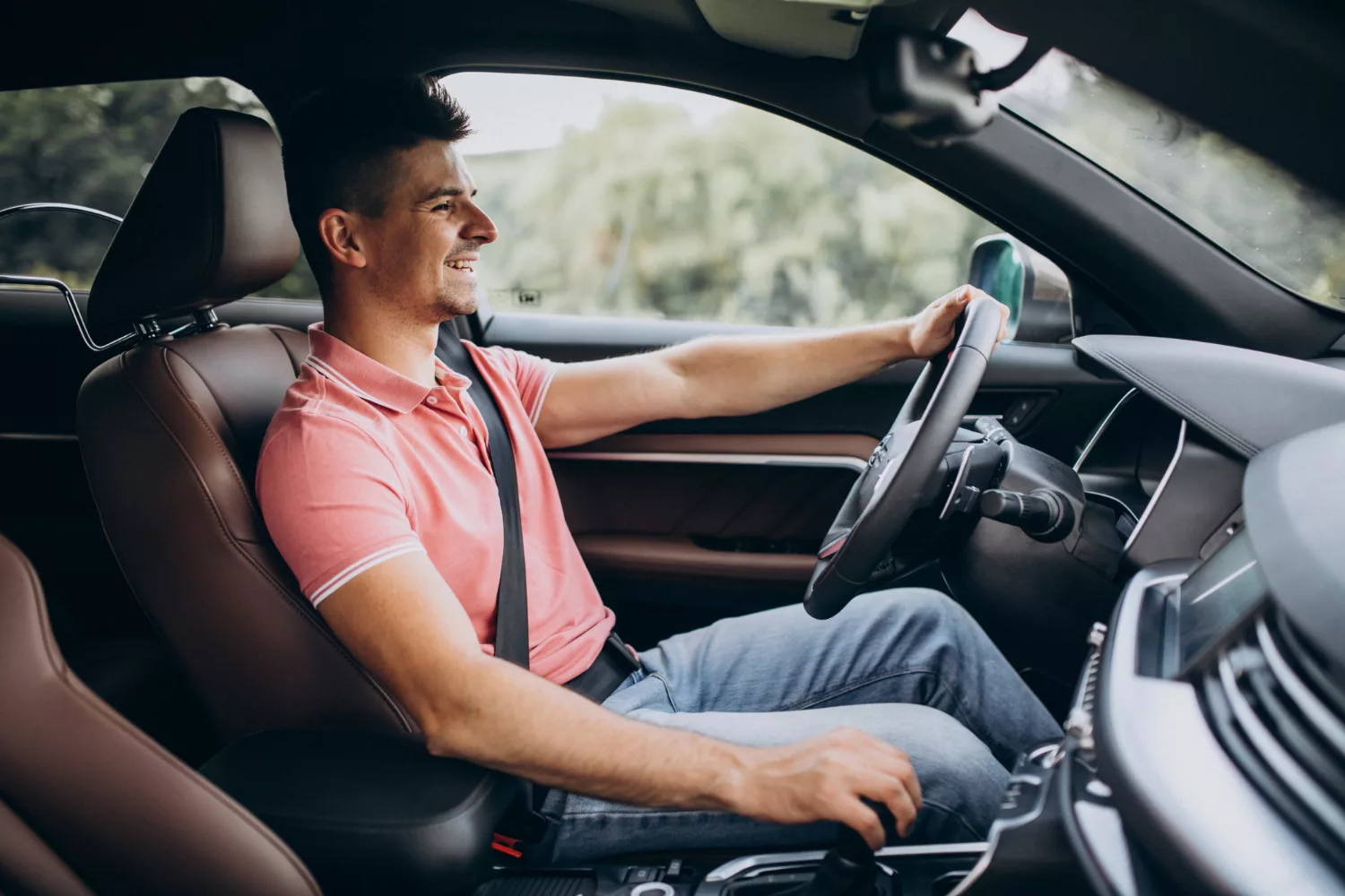 Smiling man drives car interior; features list on right highlights free shuttle, low prices, quick service.
