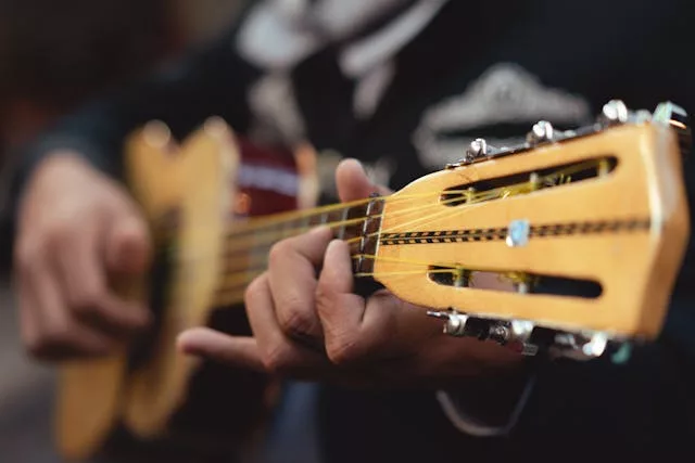 Close-up of hands strumming a classical guitar beside event details for "La Vida Loca — Live Latin Music & Dance".