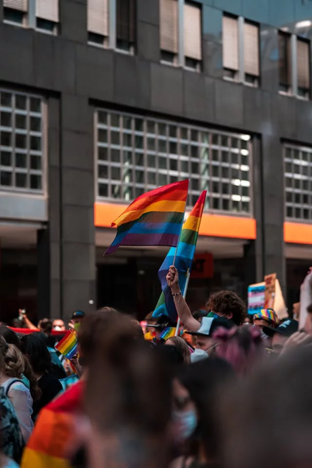 Miami Beach Pride — rainbow flags waving during a crowded Ocean Drive pride parade.