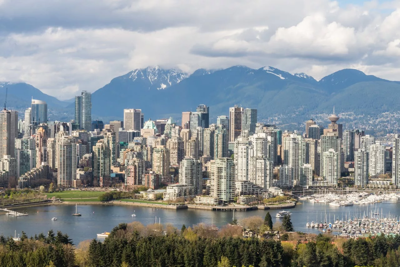 Vancouver skyline with False Creek, marina and mountains; PNE fair info and Vancouver car rental services.