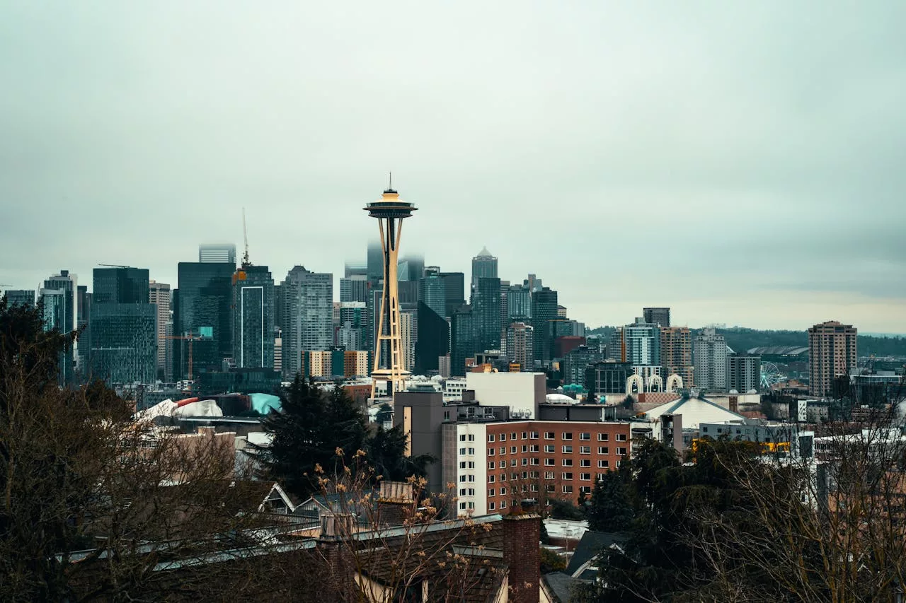 Seattle skyline with Space Needle viewed from hilltop on overcast day.