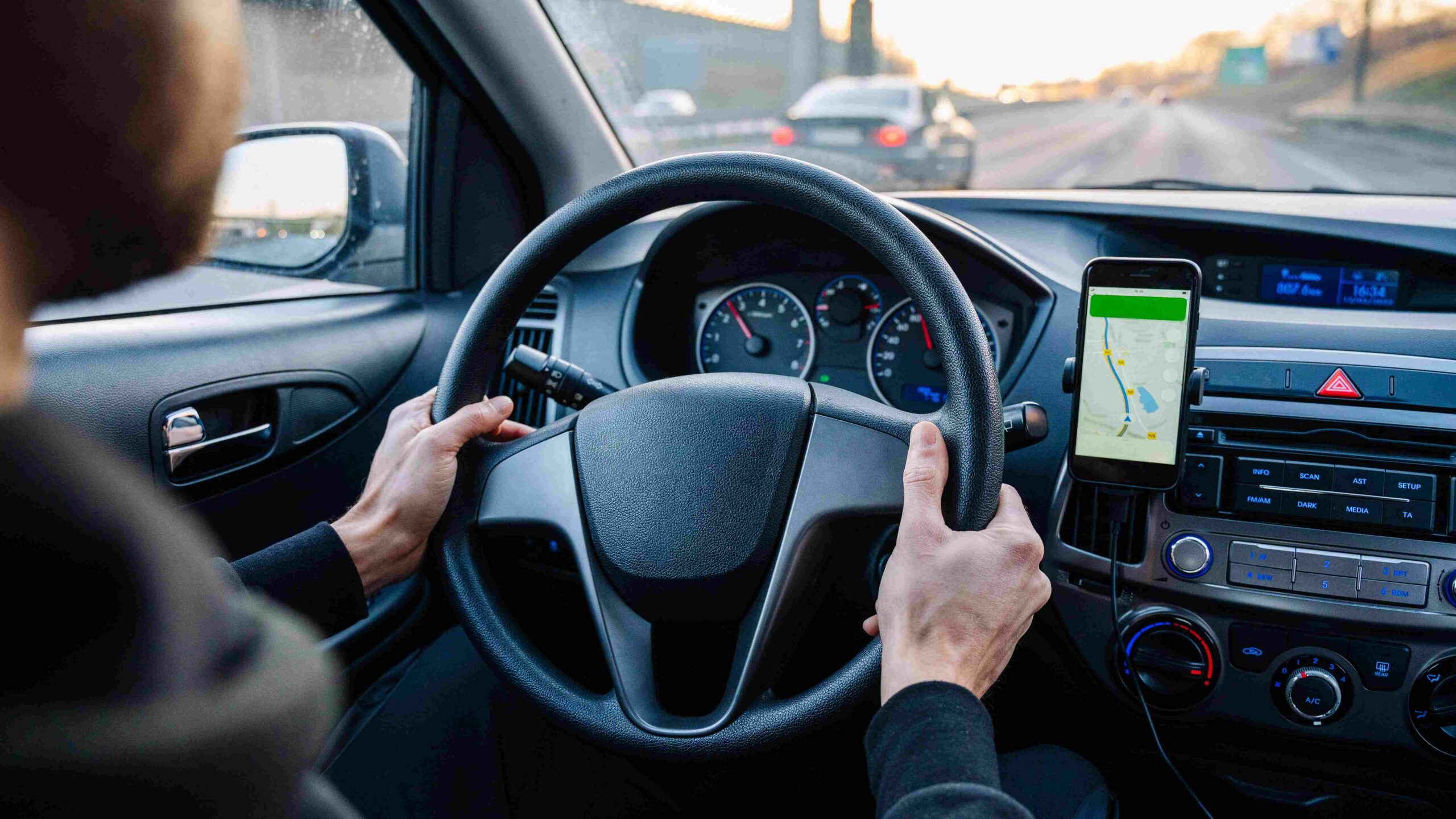 Driver using navigation during a long-distance road trip with scenic highway surroundings